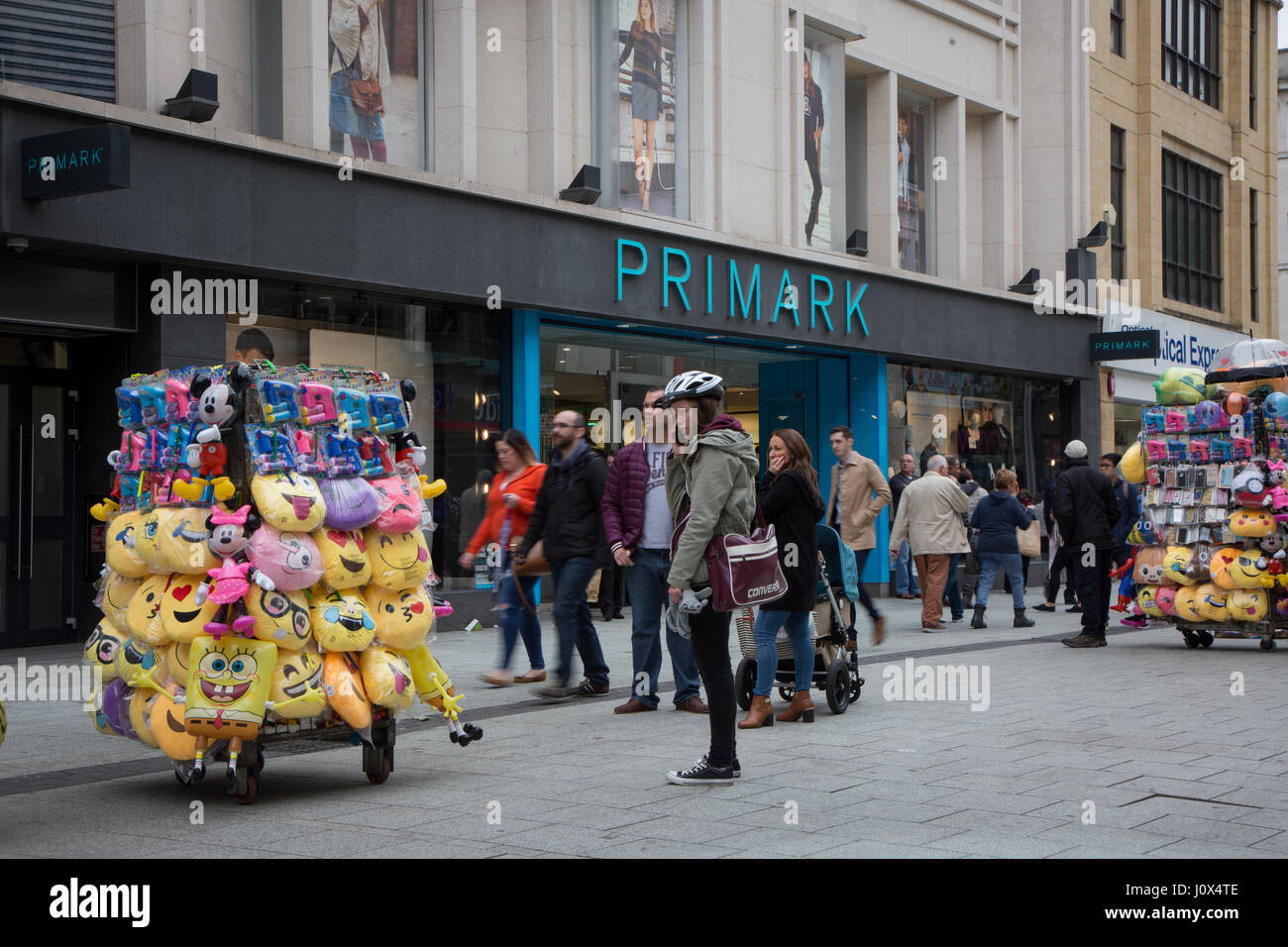 Primark on Queen Street, Cardiff. Vendors in the foreground are selling emoji cushions etc. Stock Photo