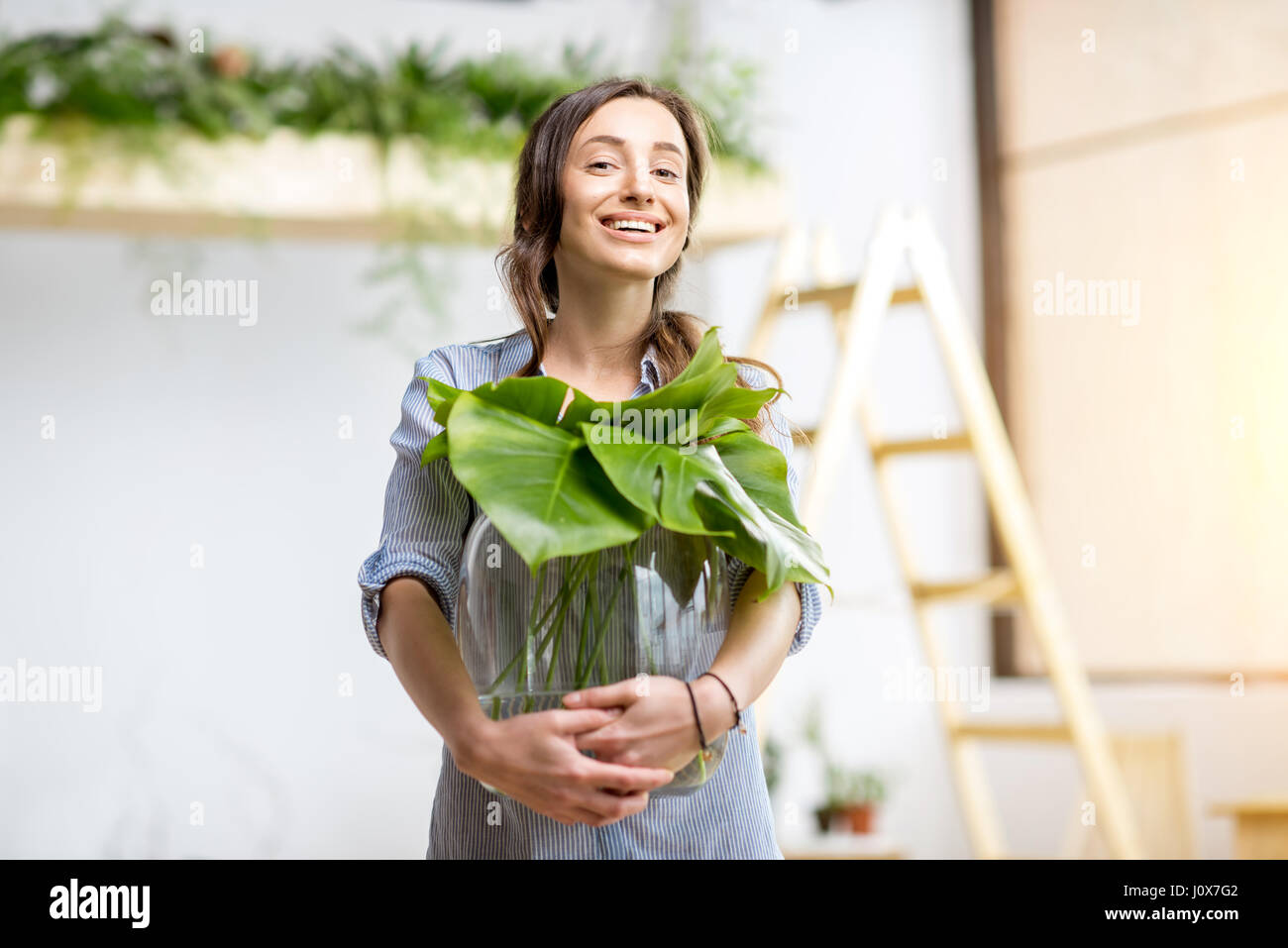 Woman with plant at home Stock Photo