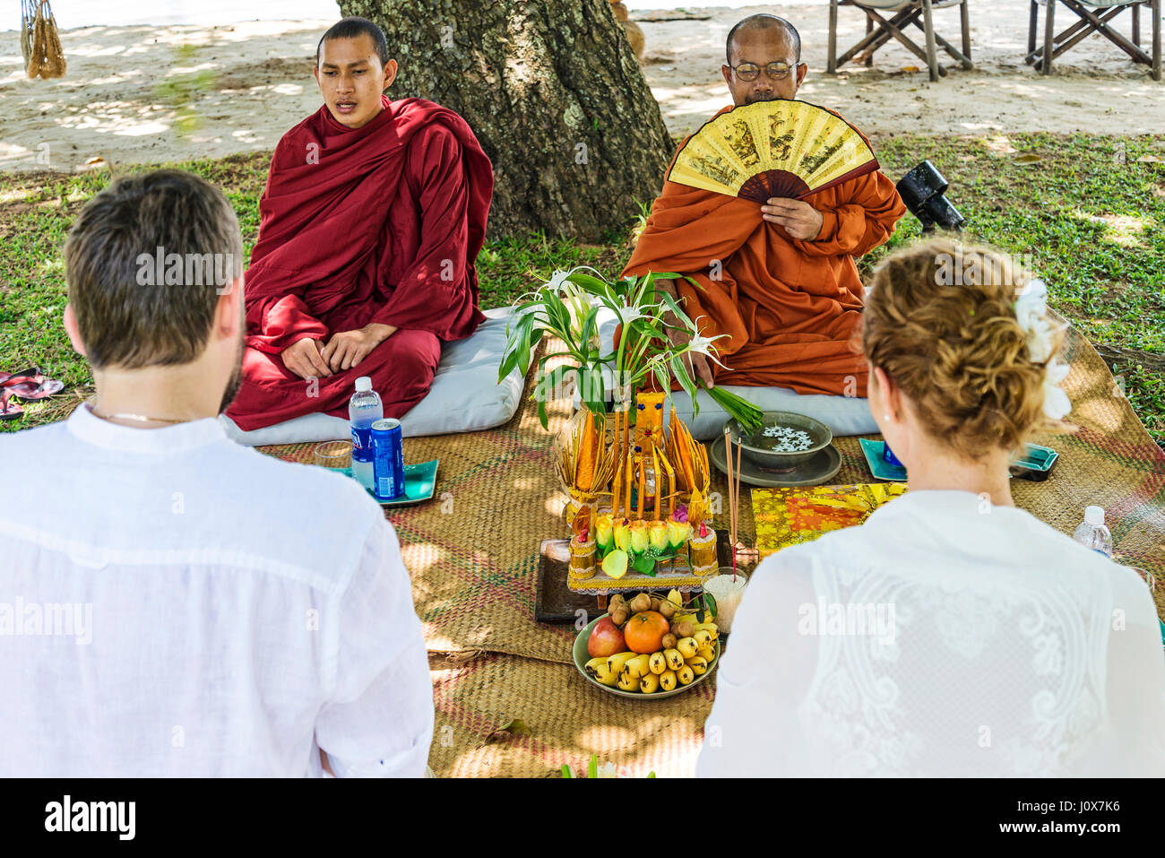 monks blessing buddhist wedding ceremony for western european couple in