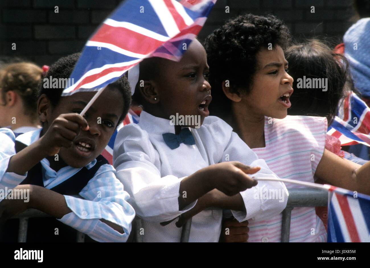 Local children waving union jack flags for Prince Charles visiting Handsworth, Birmingham Uk June 1986 Stock Photo