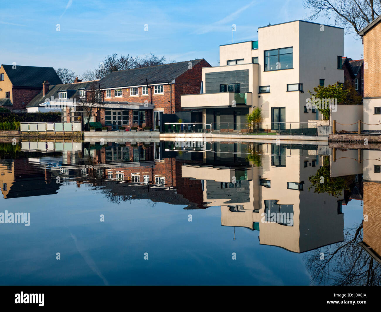 Canal side homes reflected in the Ashton Canal, Audenshaw, Tameside, Manchester, England, UK Stock Photo