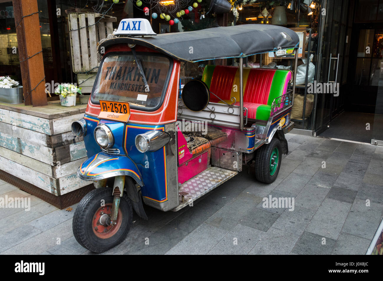 A tuk-tuk, or auto-rickshaw, on display at a Thai restaurant, Spinningfields, Manchester, England, UK Stock Photo