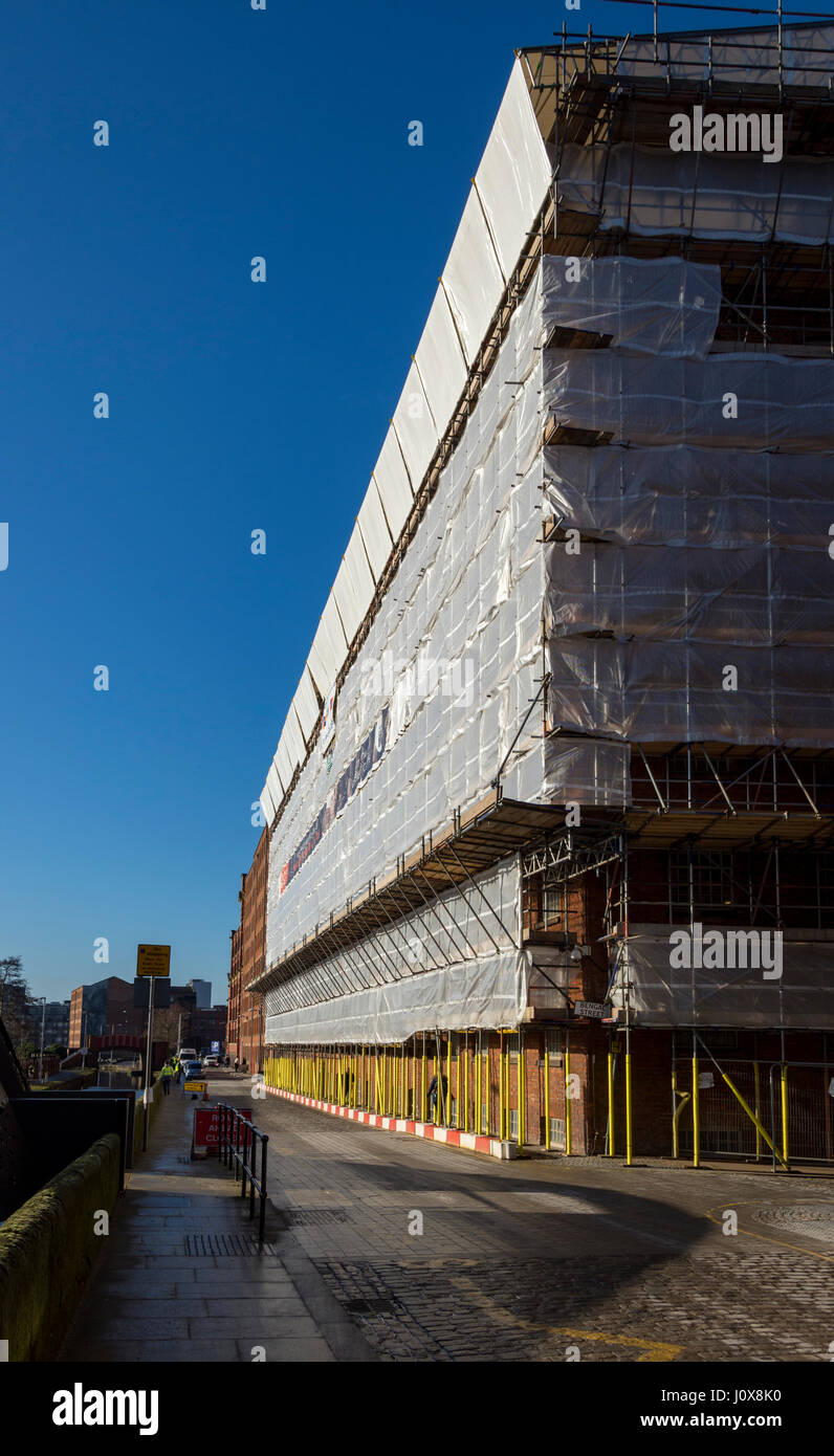 Scaffolding and protective wrapping on the Murrays' Mills complex, undergoing conversion to apartments, New Islington, Ancoats, Manchester, UK Stock Photo