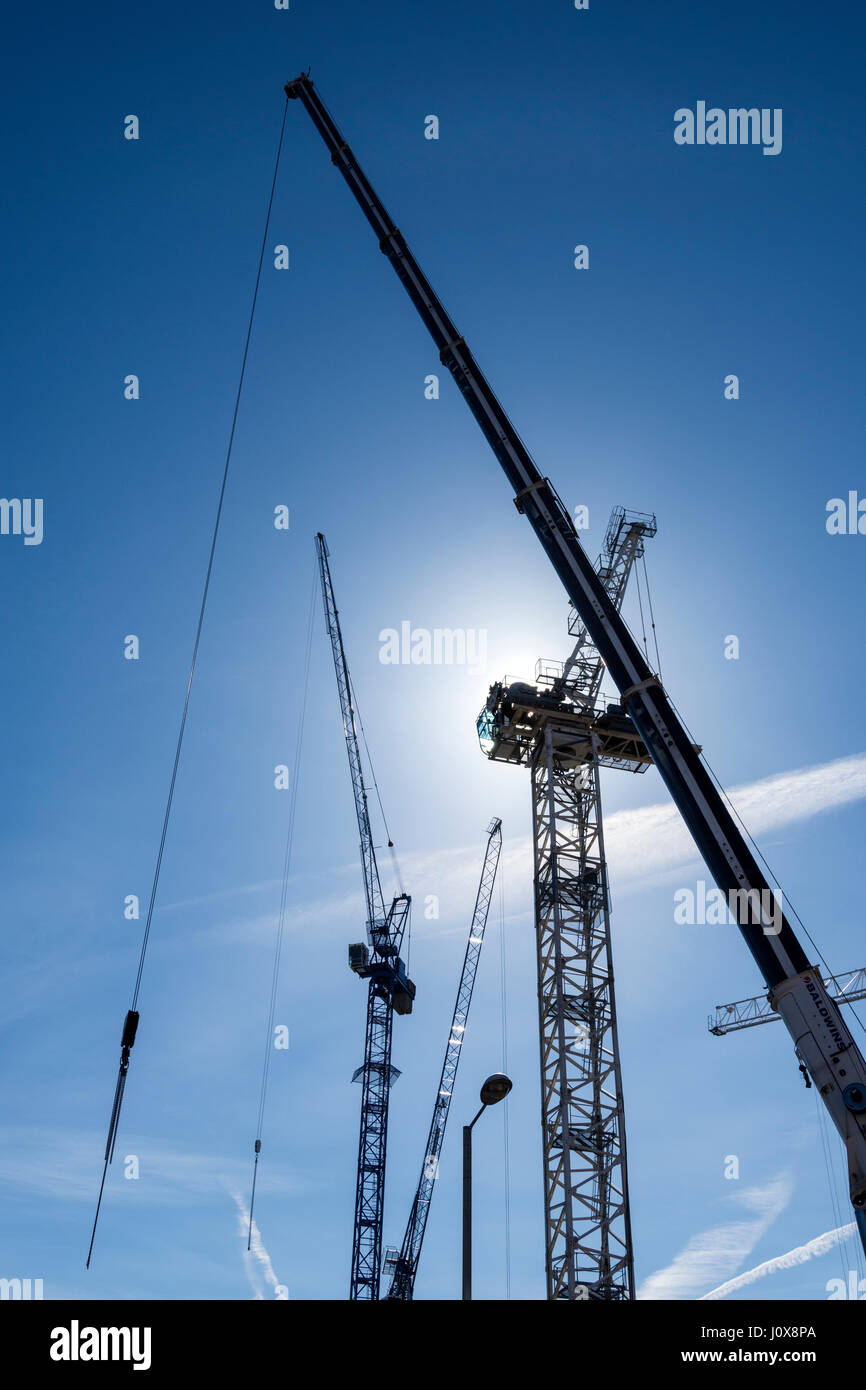 Crane jibs and a partially erected tower crane on a new development site near Cutting Room Square, Ancoats, Manchester, England, UK Stock Photo