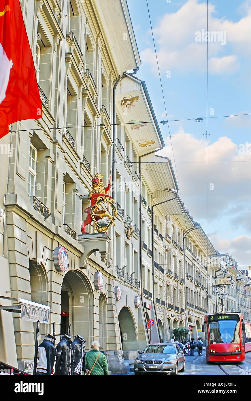 BERN, SWITZERLAND - MARCH 3, 2011: The red tram runs along historic Guild Houses of Kramgasse street, on March 3 in Bern. Stock Photo