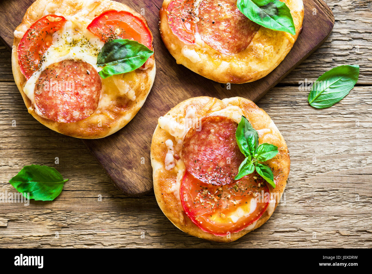 Italian Mini Pizzas With Salami Tomatoes Cheese And Basil For Snack Stock Photo Alamy