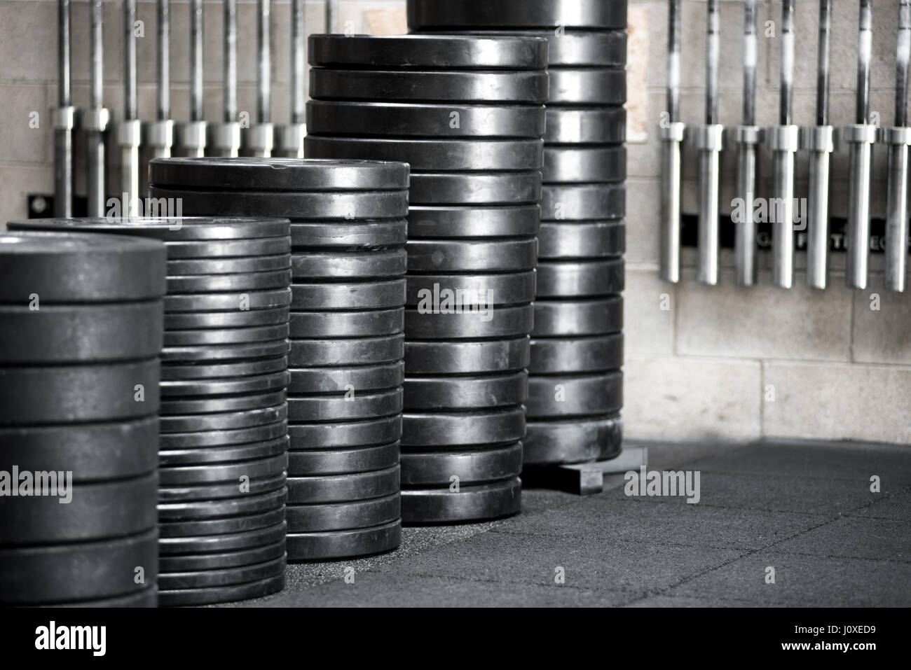 Stacks of assorted sized weights for barbells in a gym in a close up greyscale image with copy space Stock Photo