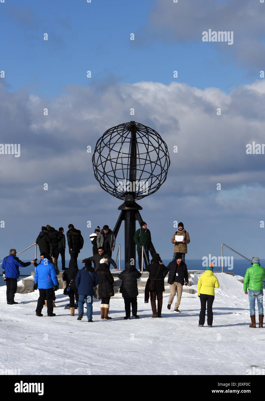 Tourists gather round the globe monument on North Cape, Nordkapp. Nordkapp, Finmark, Norway. Stock Photo