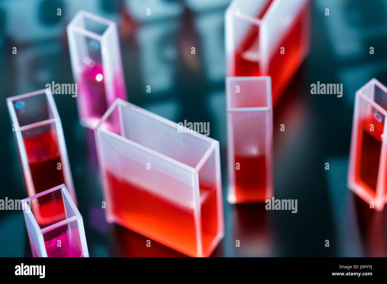 Quartz cuvette for laser chromatography with red liquid. Physical chemistry laboratory Stock