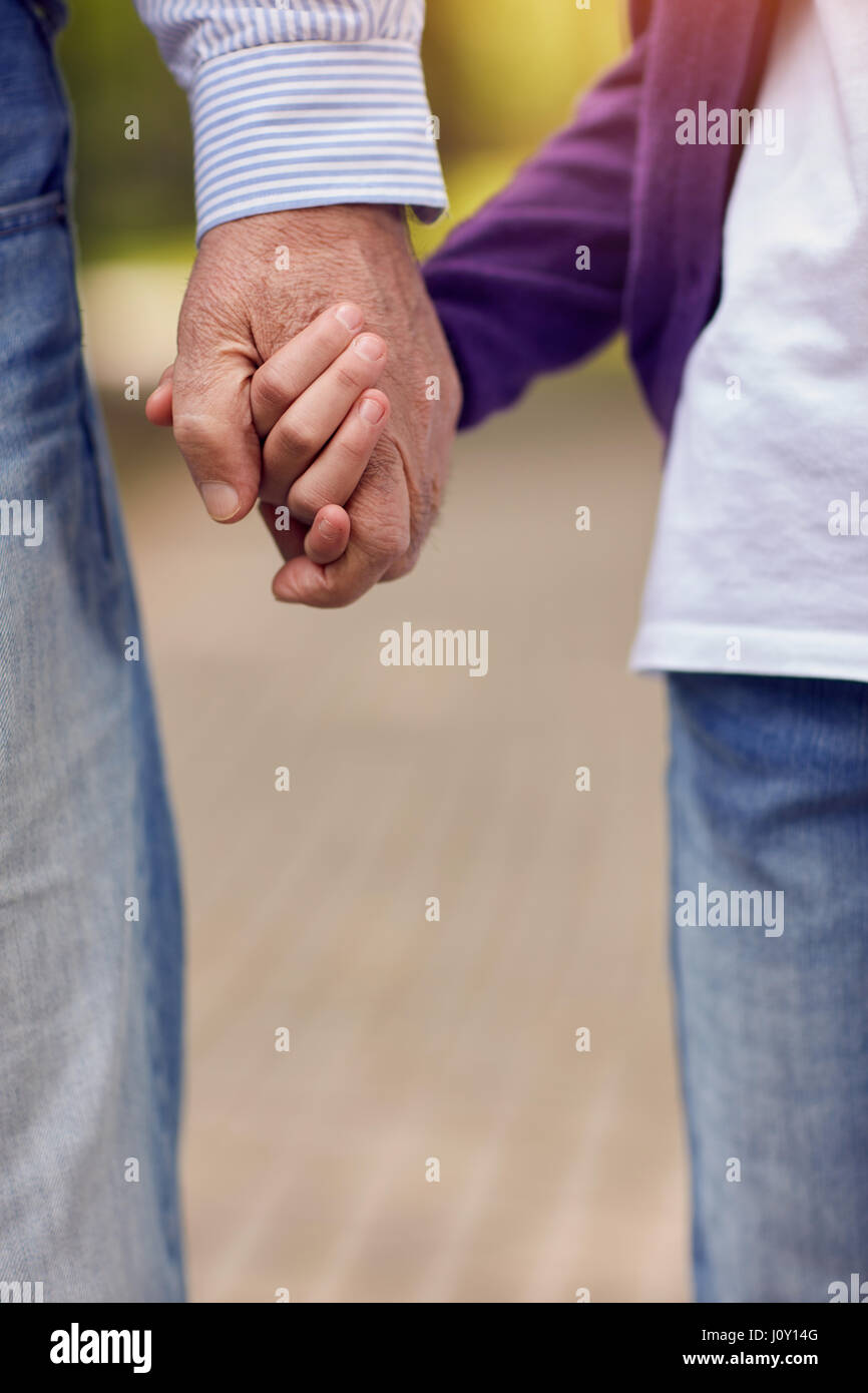 Senior and young holding hands walking in nature Stock Photo