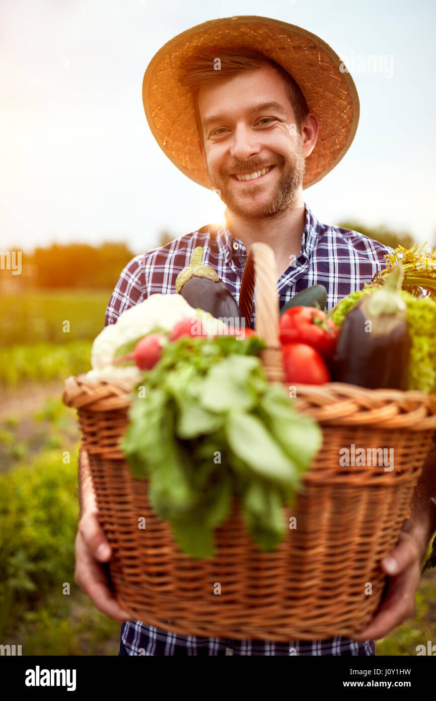 Young farmer with basket full of organic vegetables from garden Stock ...