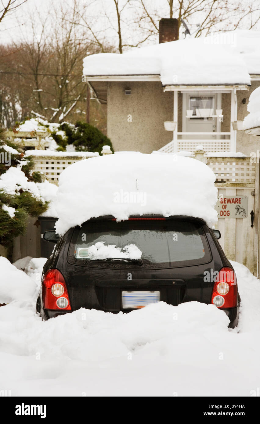 small vehicle snowed in in driveway Vancouver, BC. Canada Stock Photo