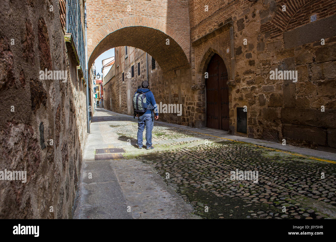 Visitor walking by arched medieval street at Plasencia Old town, Caceres, Extremadura, Spain Stock Photo