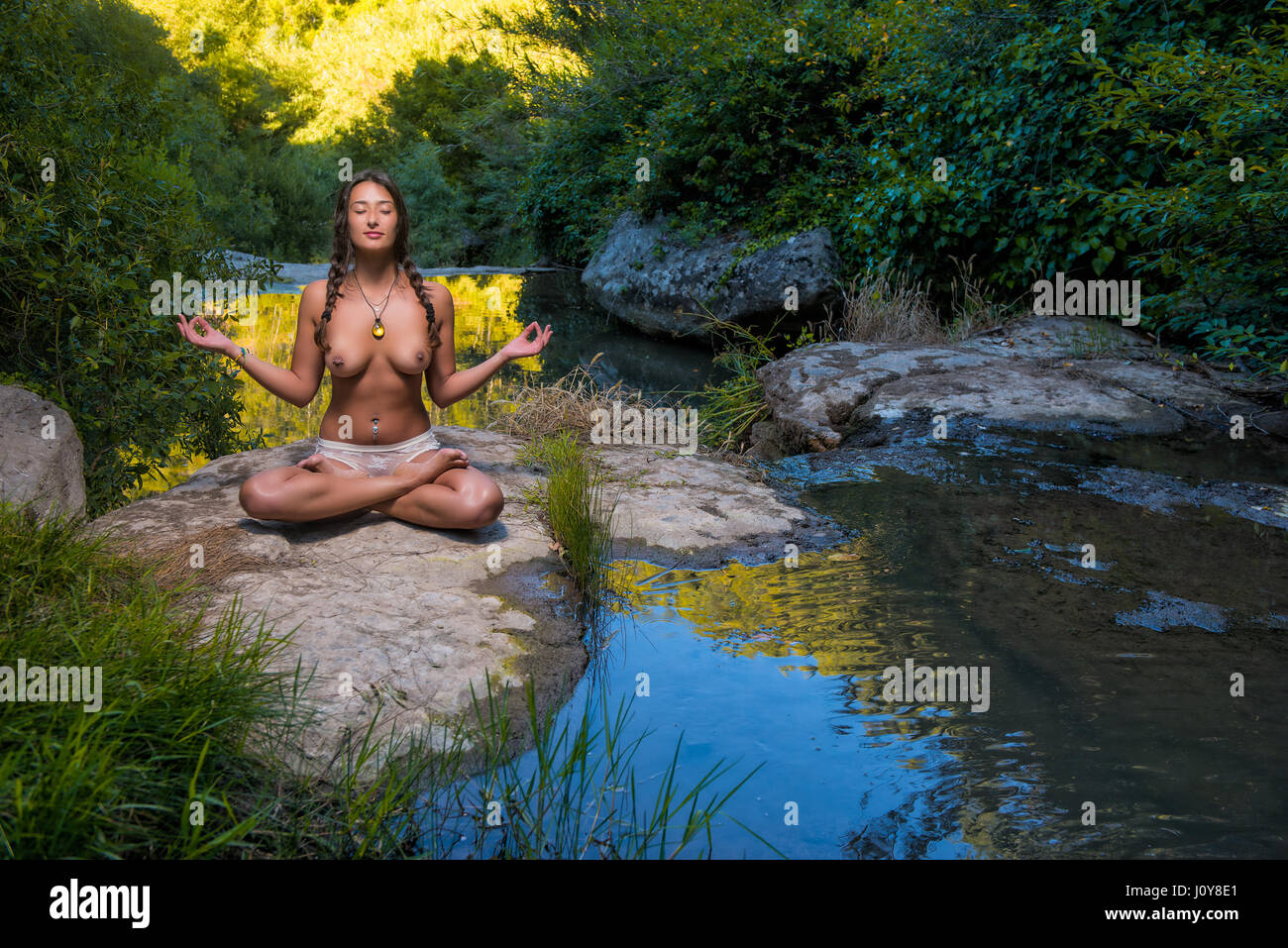 topless woman doing yoga in the nature near river Photo -