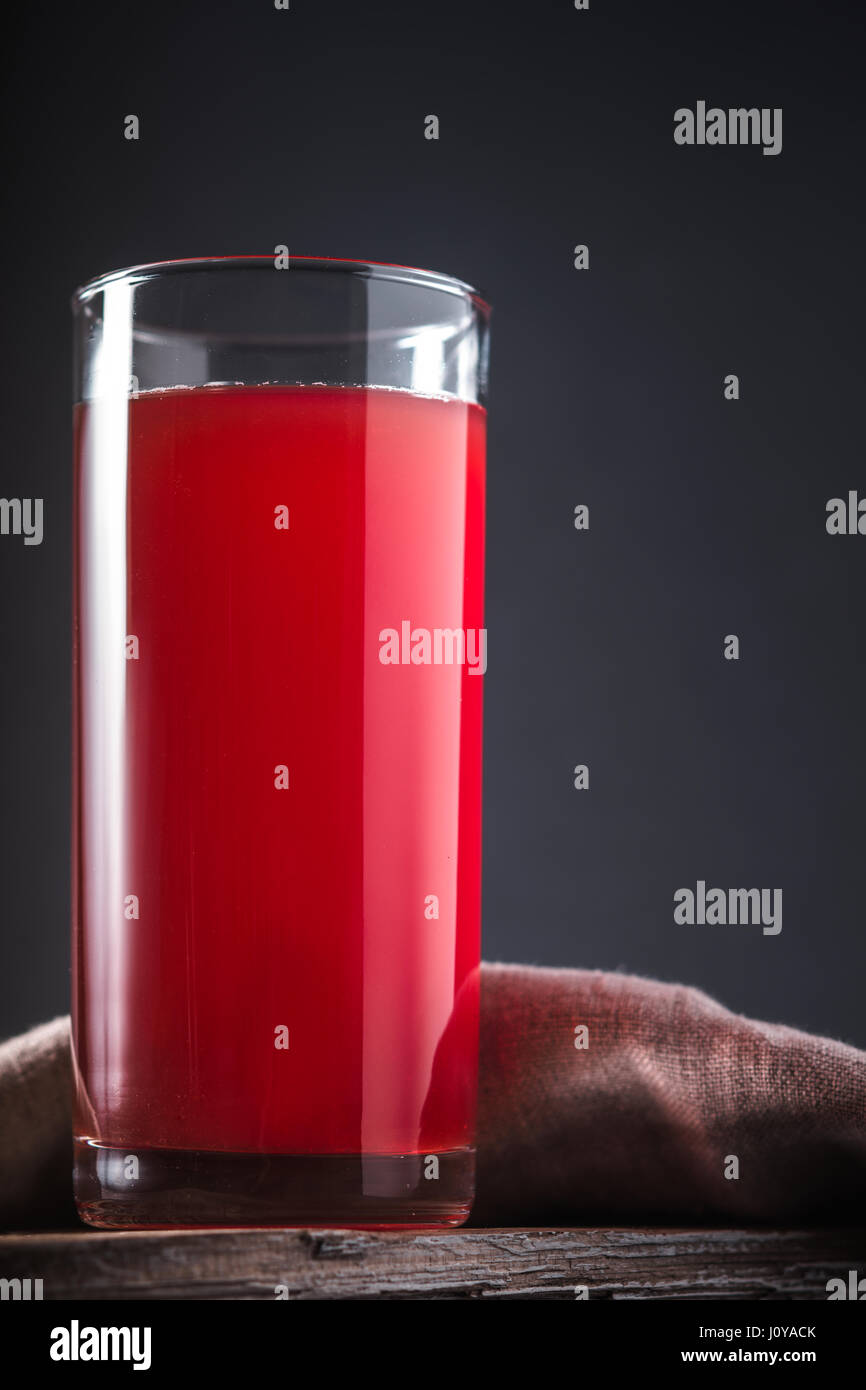 Cranberry drink in a tall glass on a gray background vertical Stock Photo