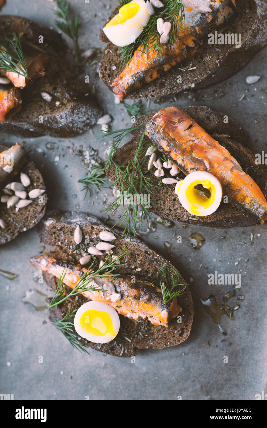 Sardines, quail egg on rye bread closeup vertical Stock Photo Alamy