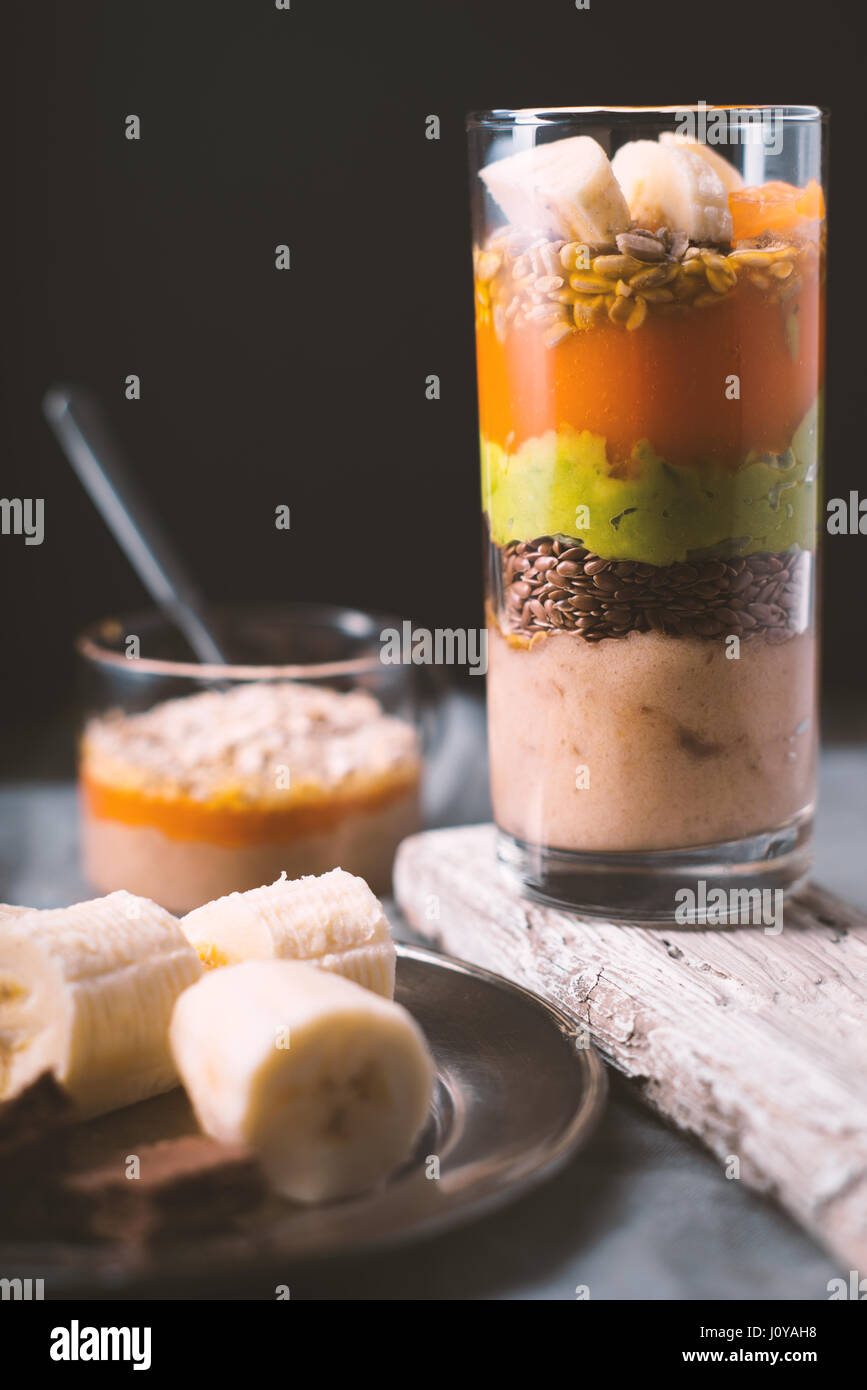 Banana smoothie, flax seed, avocado, pumpkin layers side view vertical