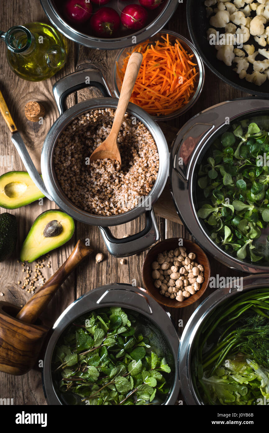 Buckwheat, carrots, avocados, grass in a bowl of water top view vertical Stock Photo