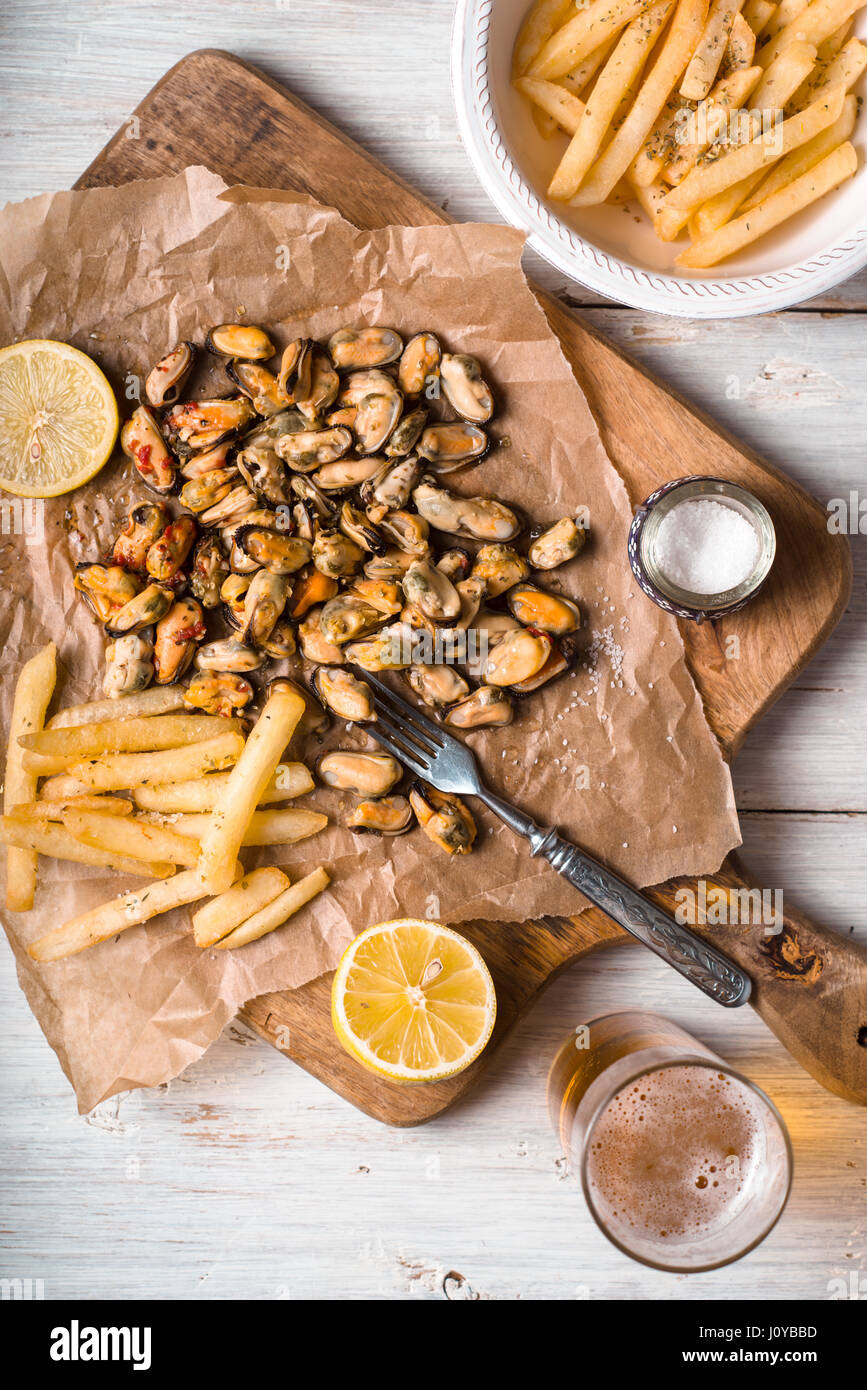 Mussels With Lemons And French Fries On The White Wooden Table Vertical Stock Photo Alamy