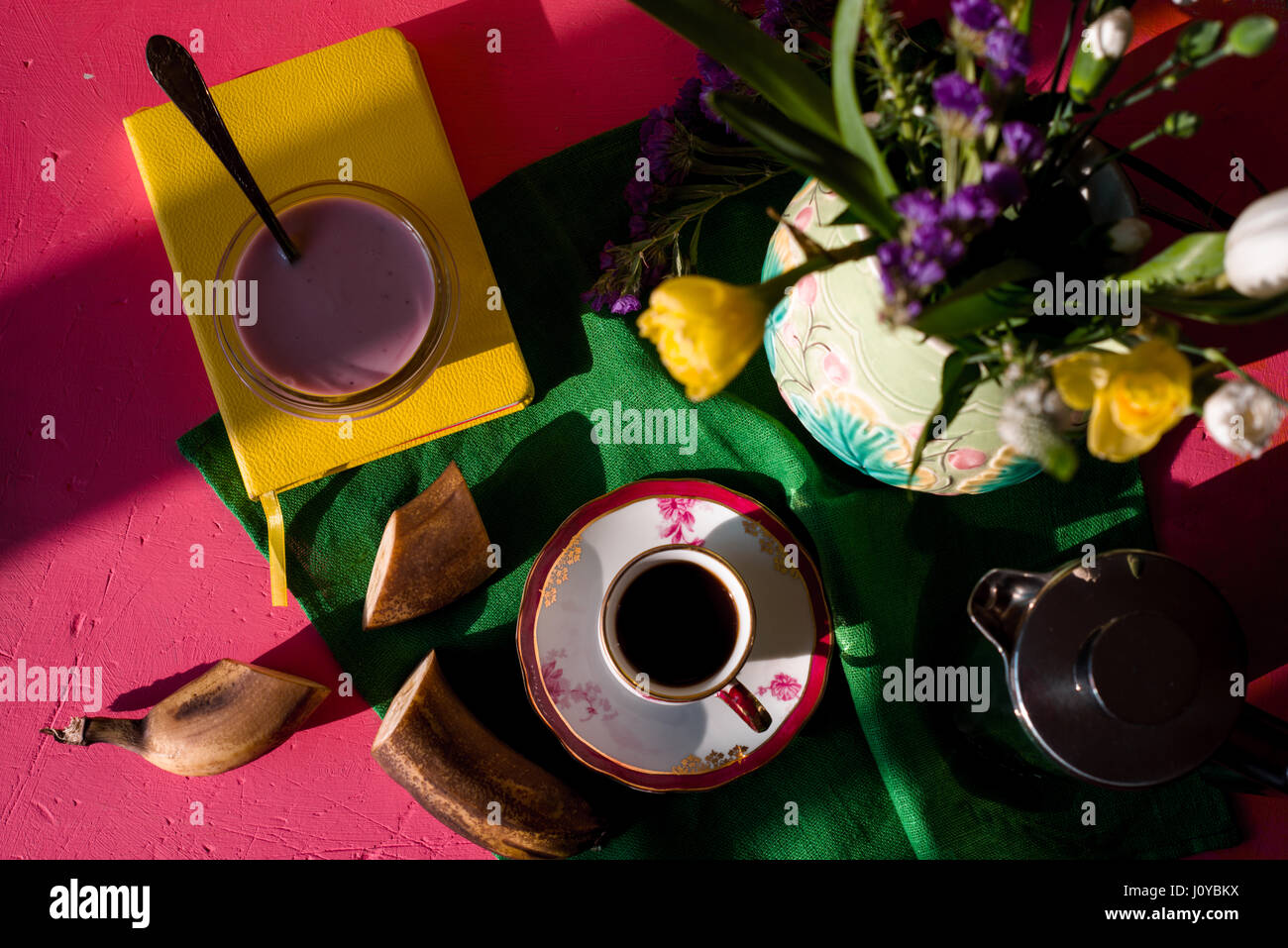 Jug with flowers, yogurt, cup of coffee on a napkin Stock Photo
