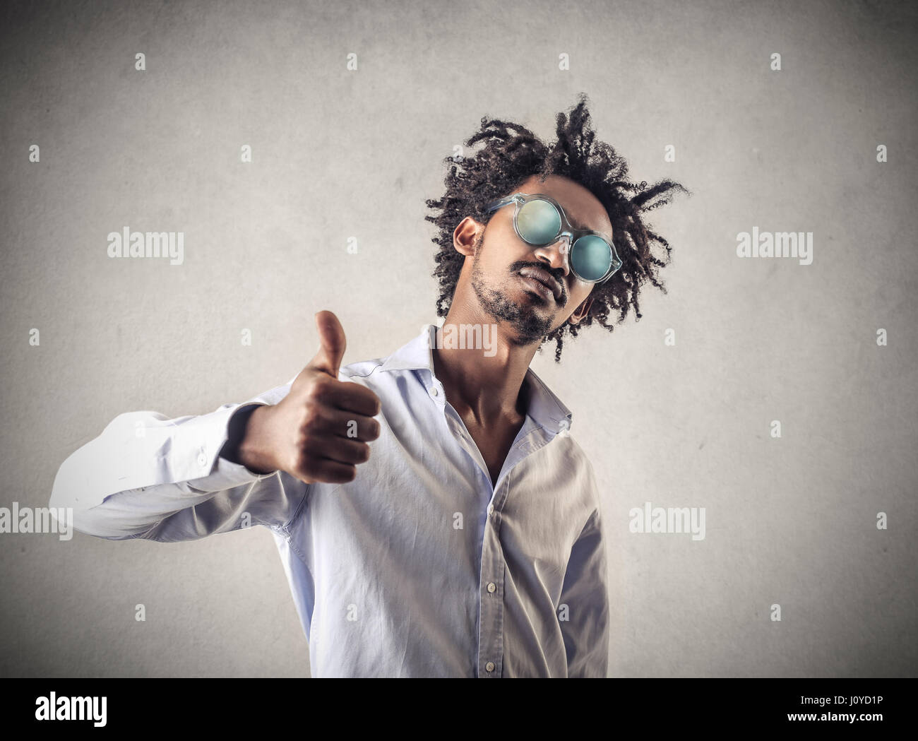 Young black man in sunglasses showing like sign Stock Photo