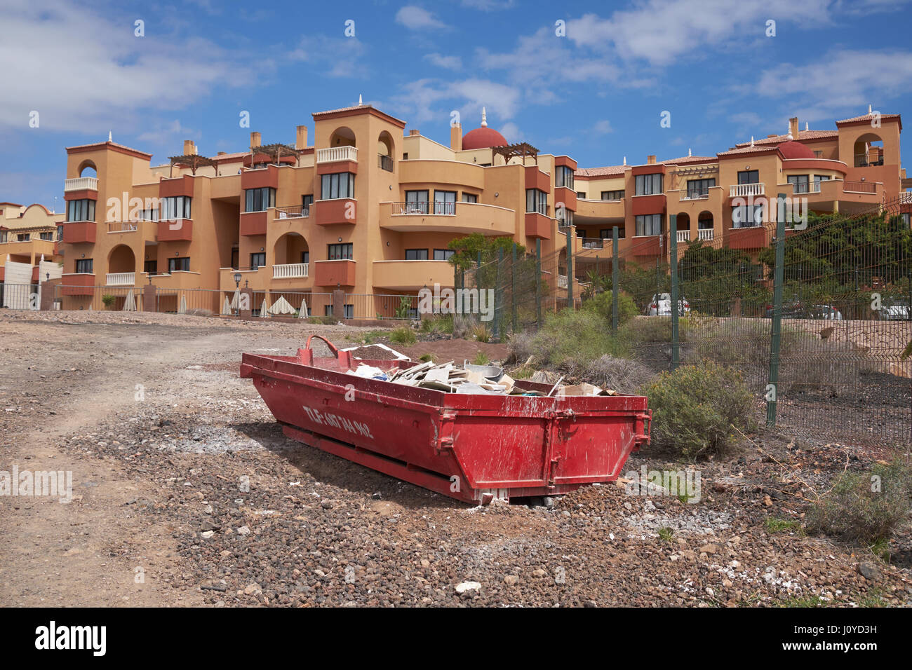 Rubbish skip on waste ground next to a hotel complex at Golf del Sur, San Miguel de Abona, Tenerife, Canary Islands, Spain. Stock Photo