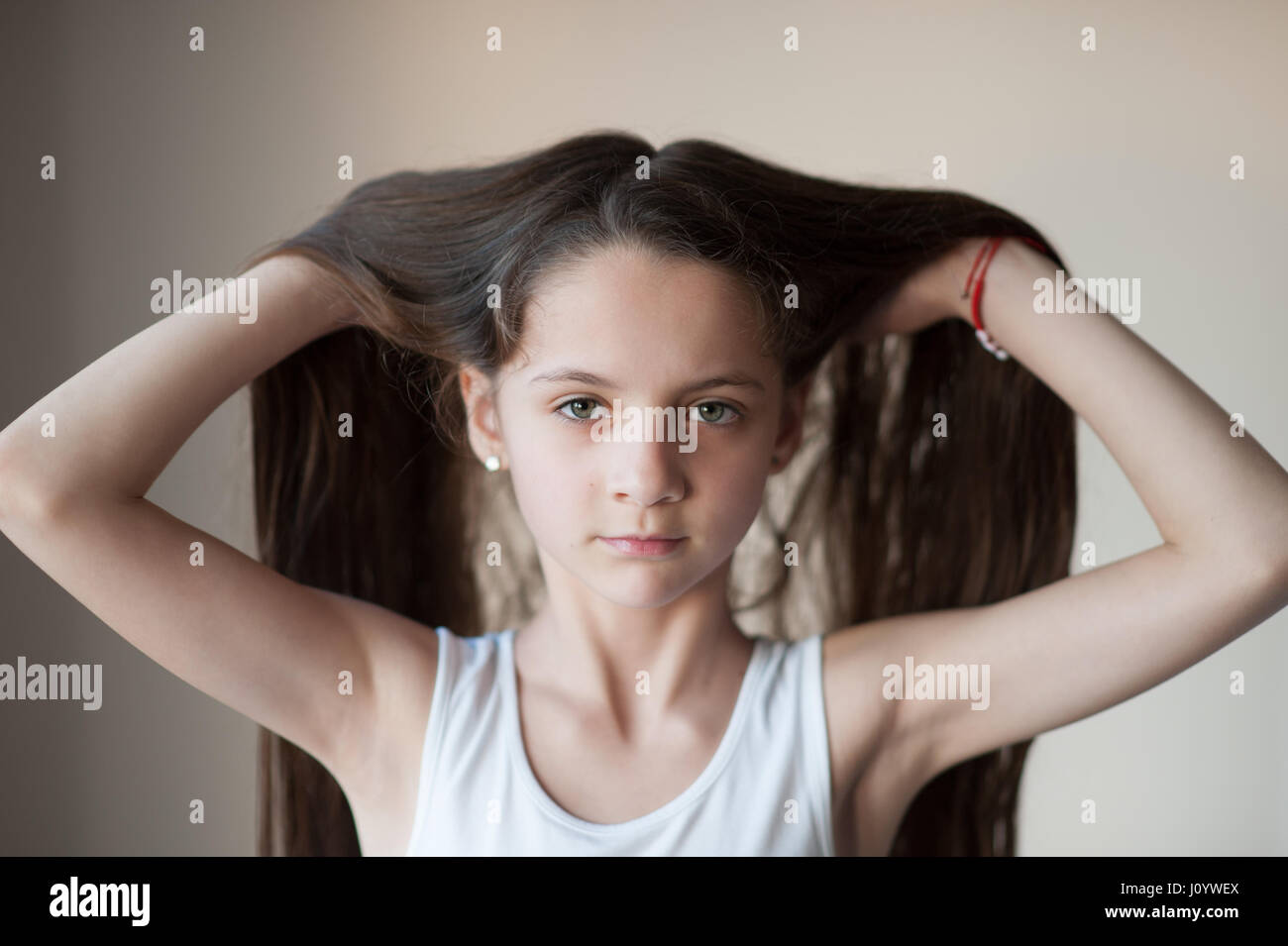 beautiful young girl in a Tshirt lifting up her hair with two hands