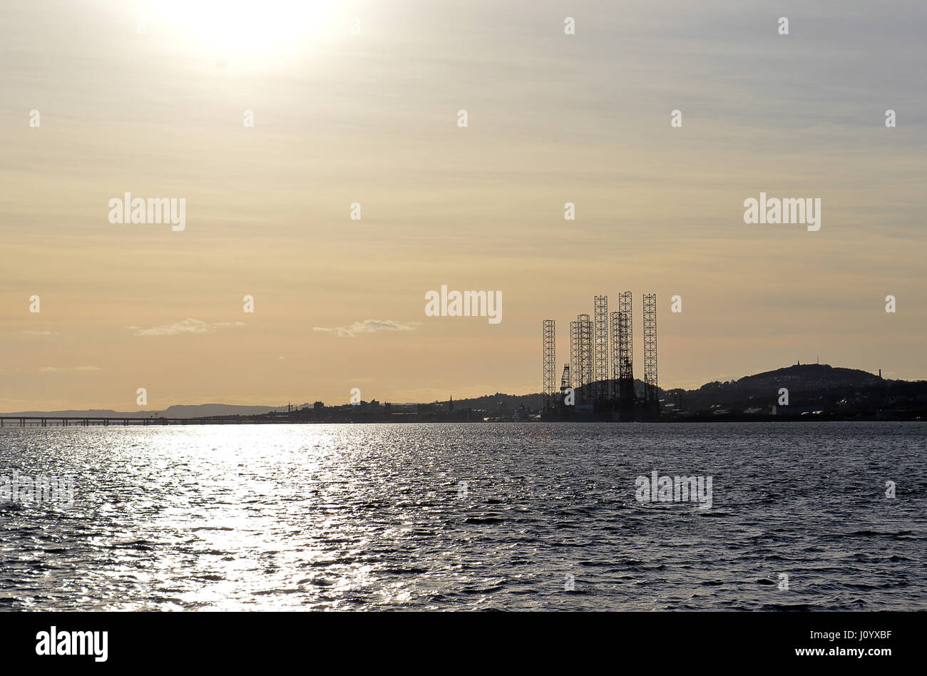 DUNDEE, SCOTLAND - 2 APRIL 2017: Late evening sun falls on the Firth of Tay with the port of Dundee and oil platforms in the background Stock Photo