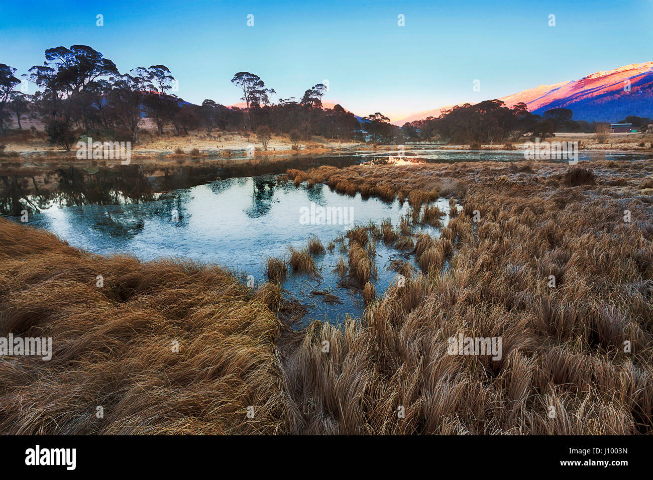 Thredbo valley of river and ponds aroung Crackenback resort in SNowy mountains of Australia. Cold winter morning set ice on pond's water and frost on  Stock Photo