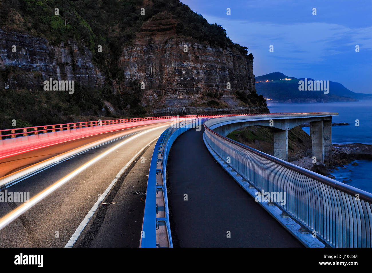 Sea Cliff bridge late night traffic on Grand Pacific drive highway at Pacific ocean edge in Australia. Stock Photo