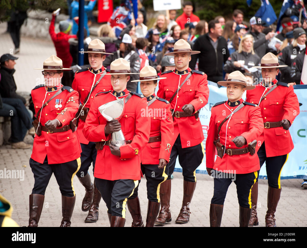 Royal Canadian Mounted Police, or RCMP officers in traditional dress red serge uniforms parade during the Canada Cup.  Whistler BC, Canada. Stock Photo