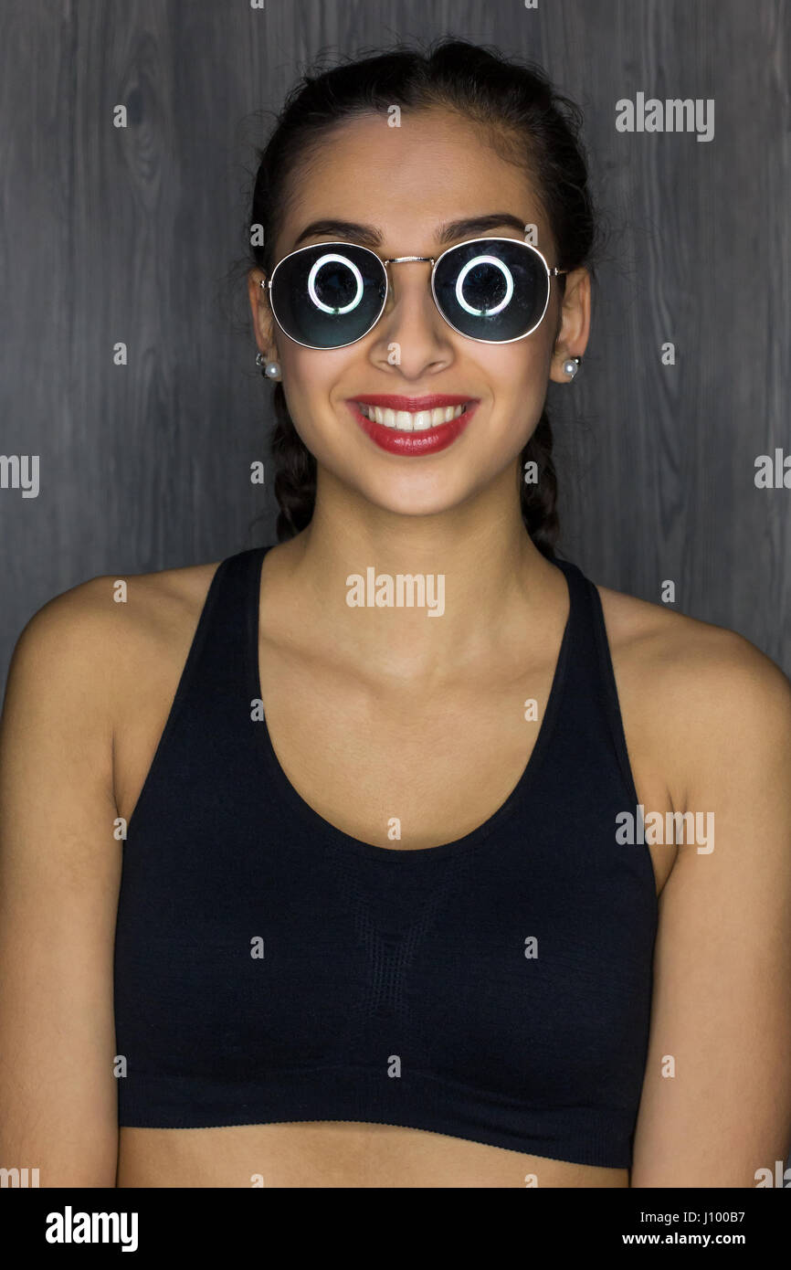 Portrait of a young woman with sunglasses, laughing Stock Photo