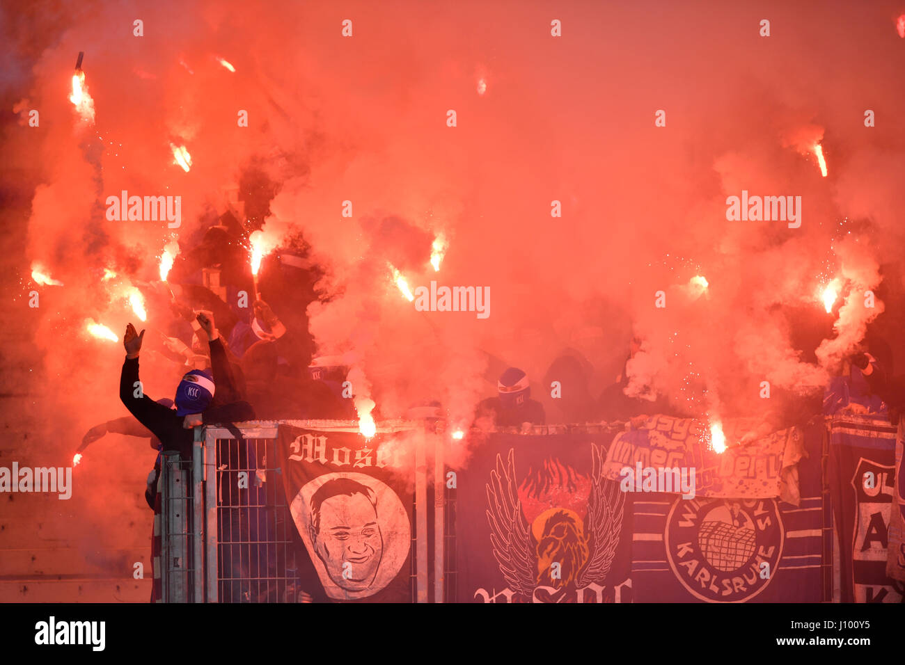 Radical fans at soccer match, hooded hooligans with Bengal light, pyrotechnics, fan section KSC Karlsruher SC Stock Photo