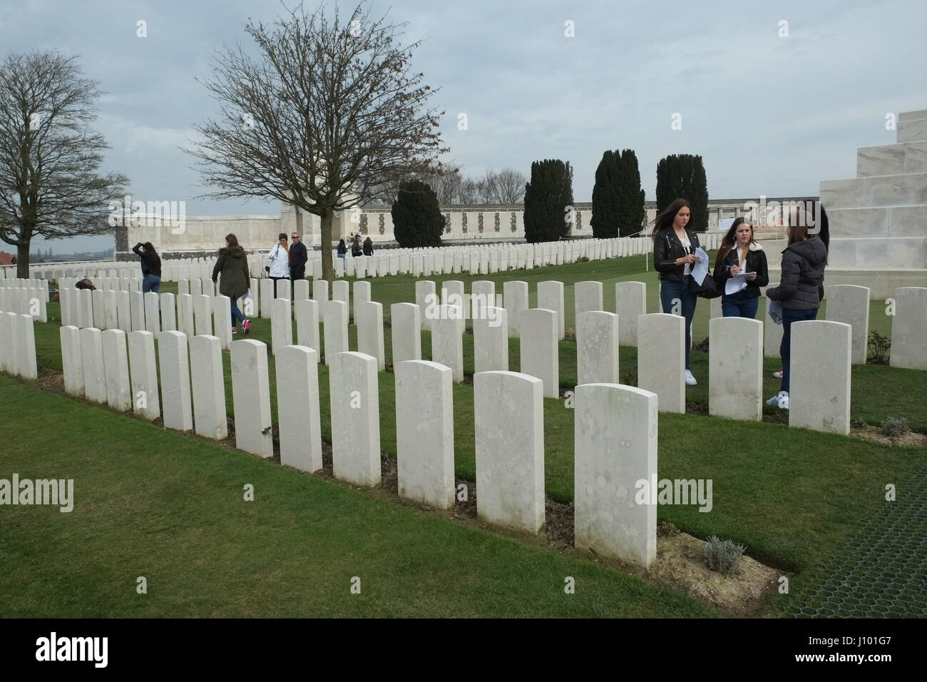 School group standing before a grave at the Tyne Cot Memorial in Passendale Stock Photo