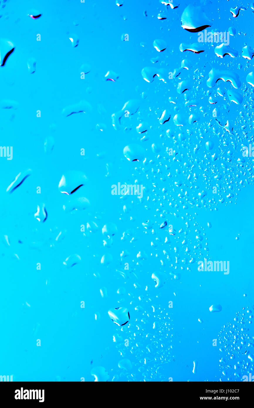 Drops on the glass rain blue background Stock Photo - Alamy
