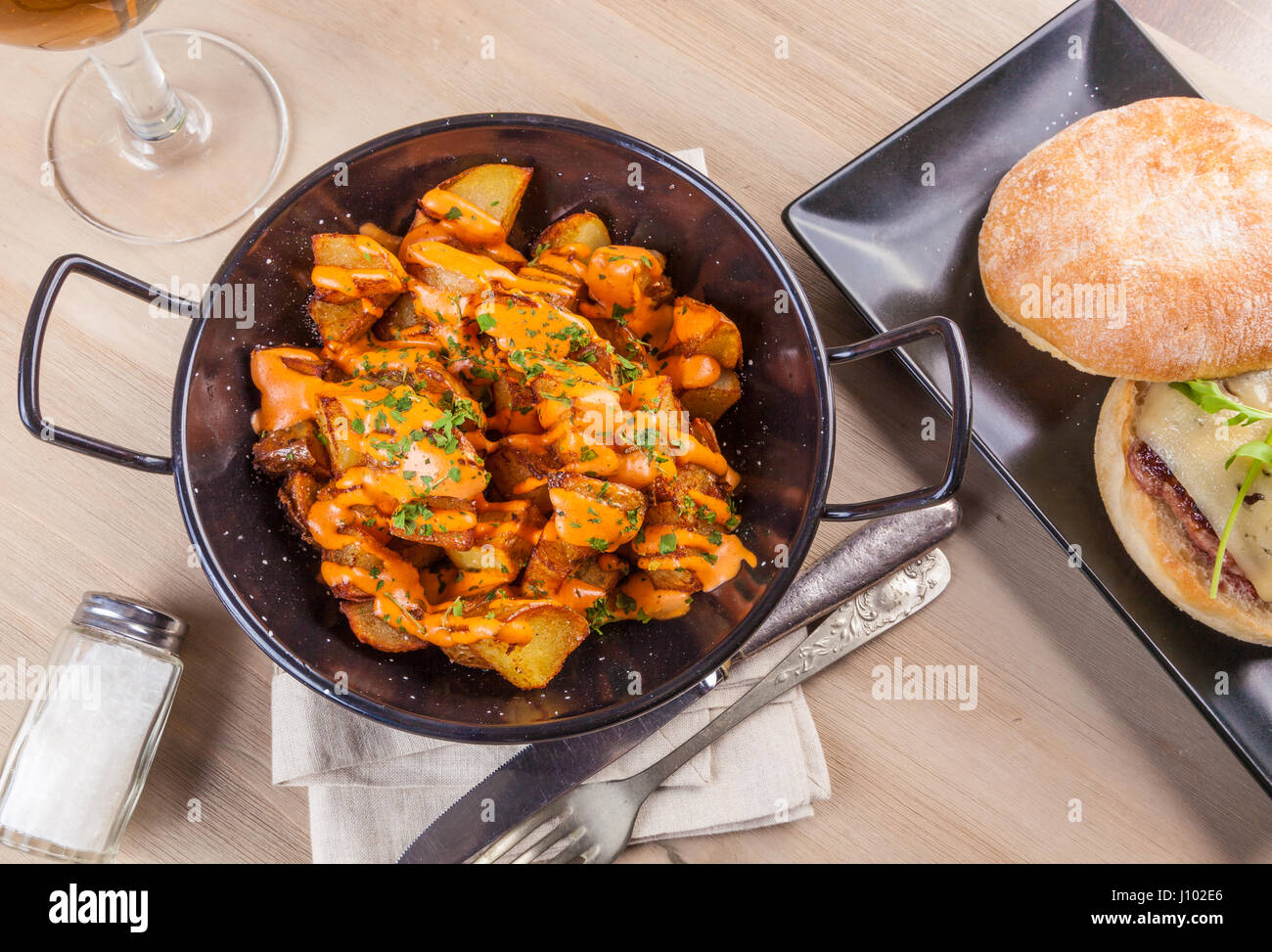 Patatas bravas, spicy potatoes, a typical Spanish dish with fried potato cubes and a spicy garlic sauce. Stock Photo