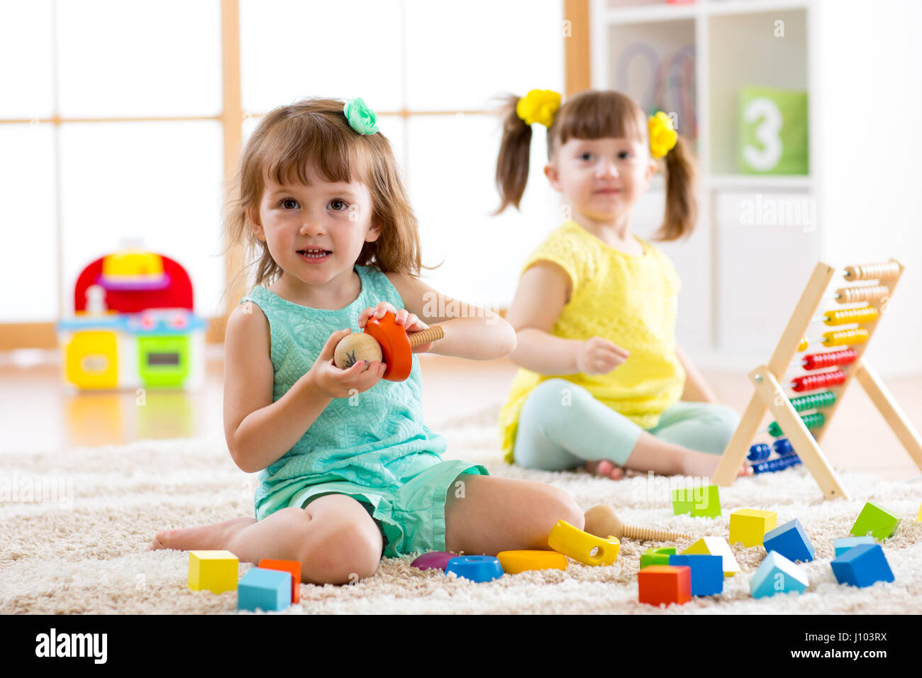 Adorable children playing colorful toys in kindergarten Stock Photo - Alamy