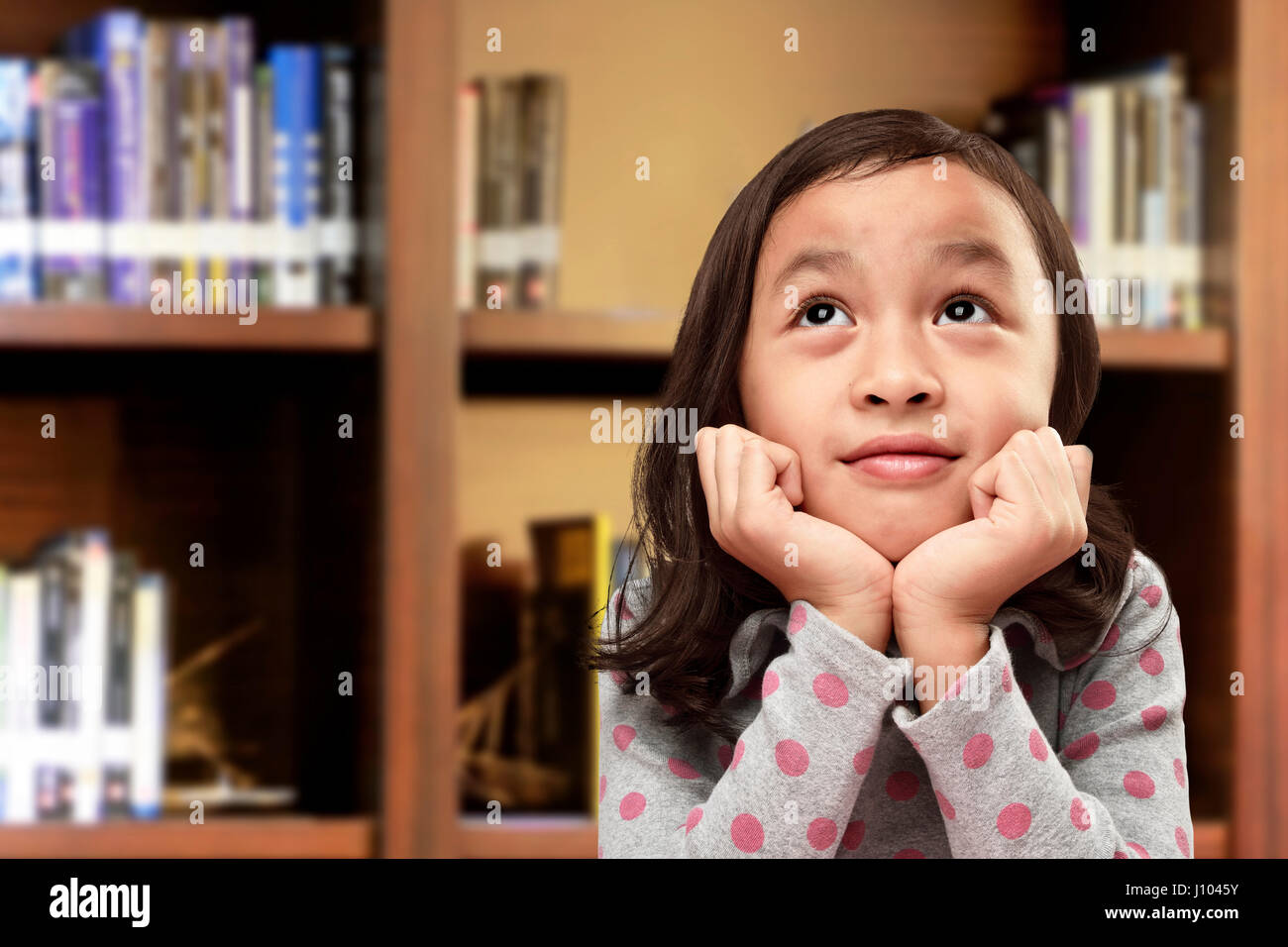 Happy asian little girl with funny expression on the library Stock Photo