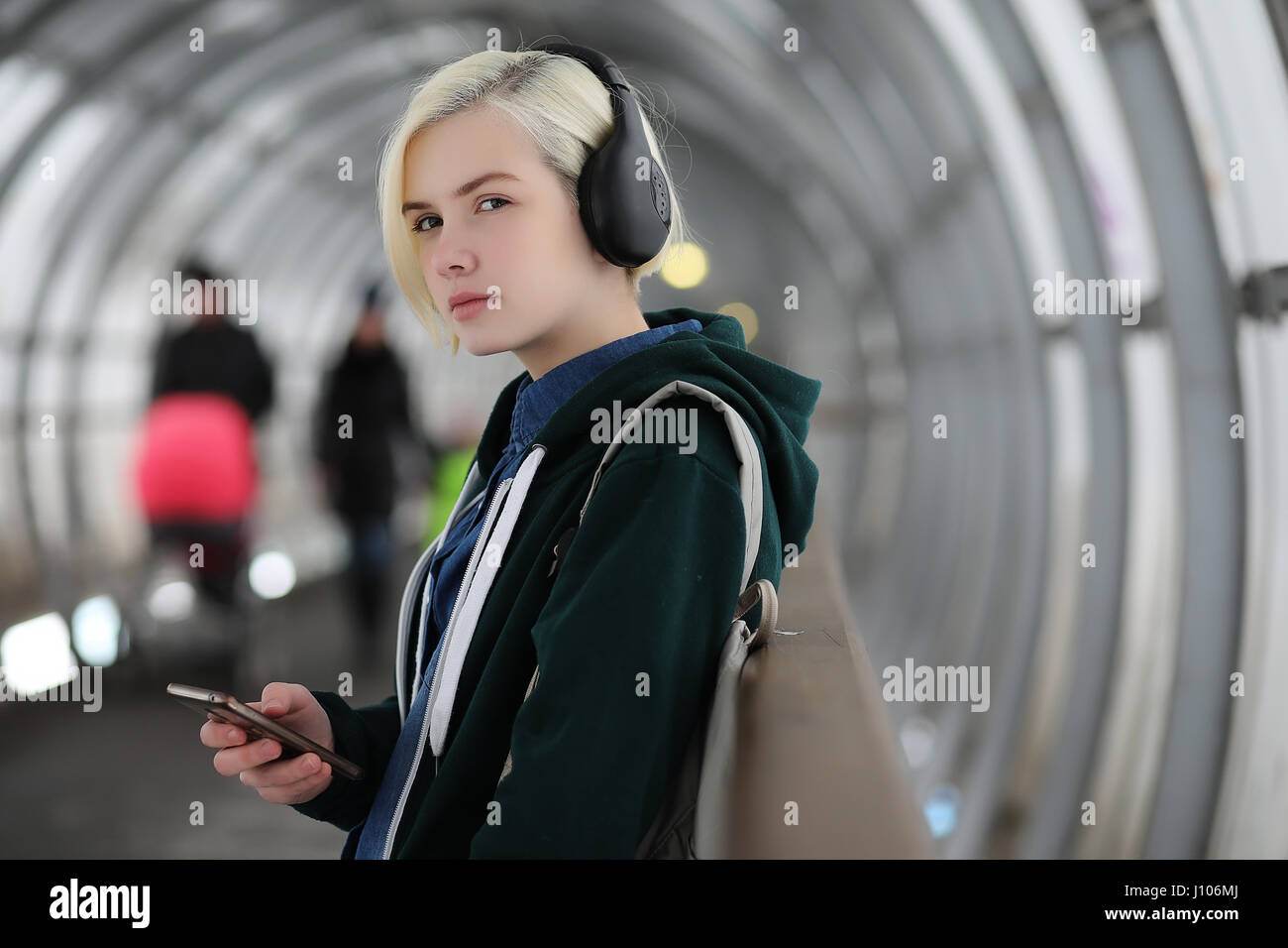 Young girl listens to music in big headphones in the subway Stock Photo Alamy