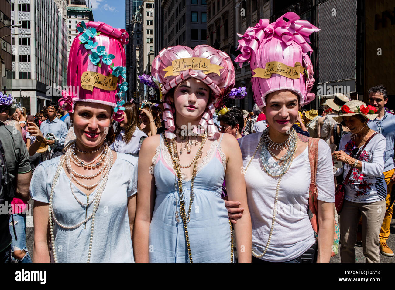 New York, USA. 16th Apr, 2017. Three women in Marie Antoinette-style headwear, all bearing the label 'Let them eat cake.' at New York's annual Easter Bonnet Parade and Festival on Fifth Avenue. Credit: Ed Lefkowicz/Alamy Live News Stock Photo