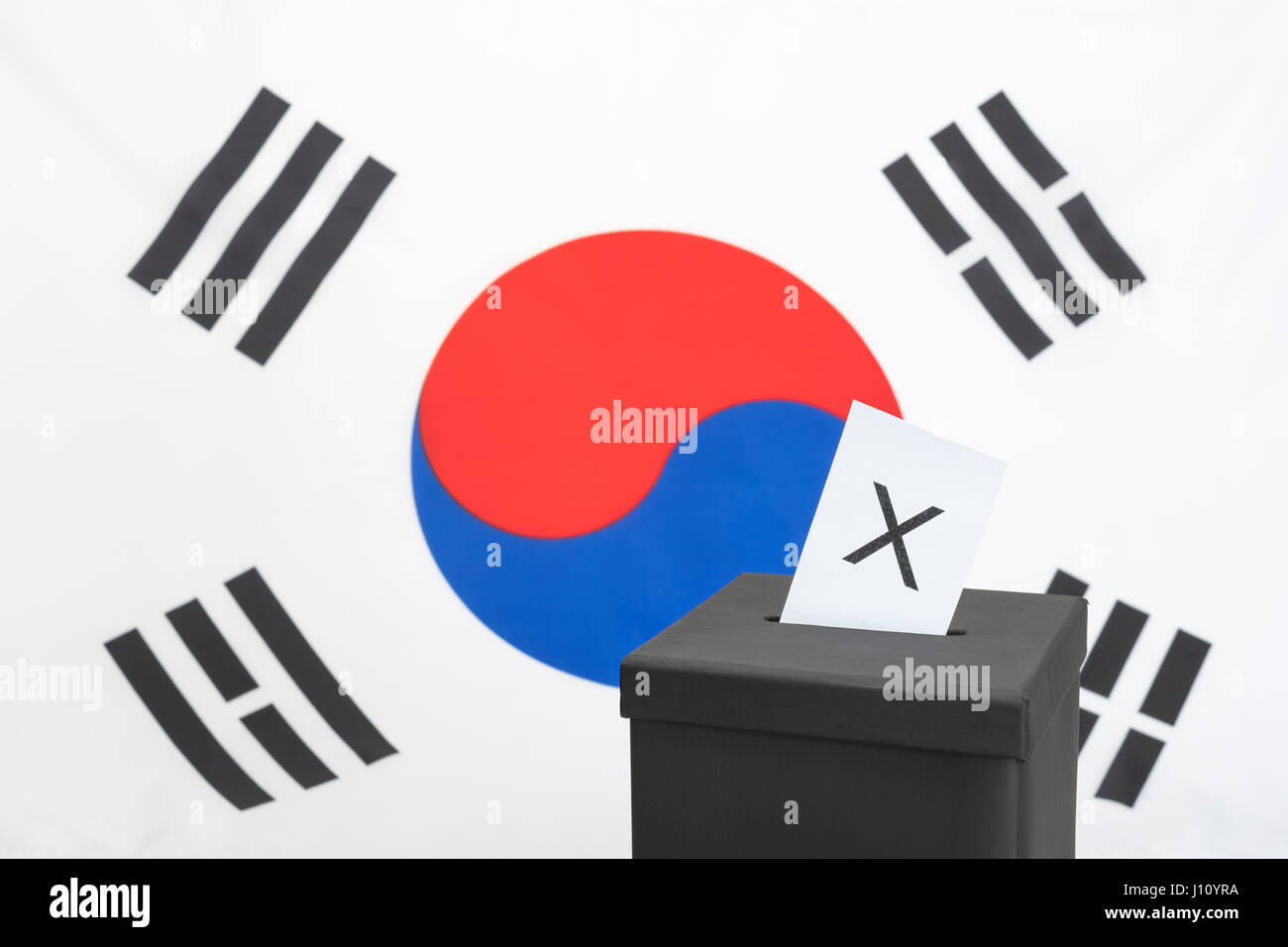 Replica black election ballot box set against South Korean flag