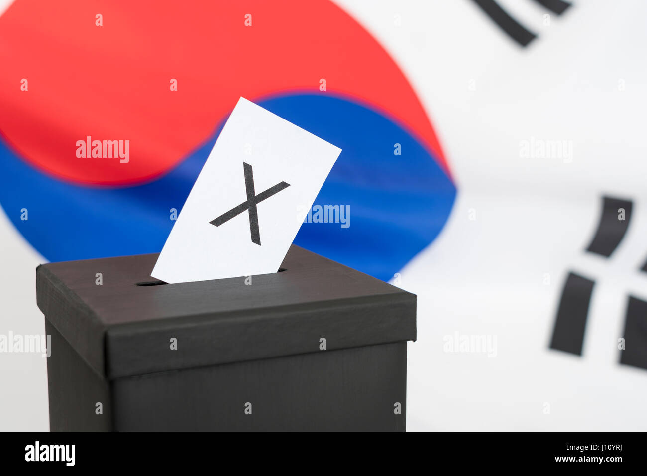 Replica black election ballot box set against South Korean flag