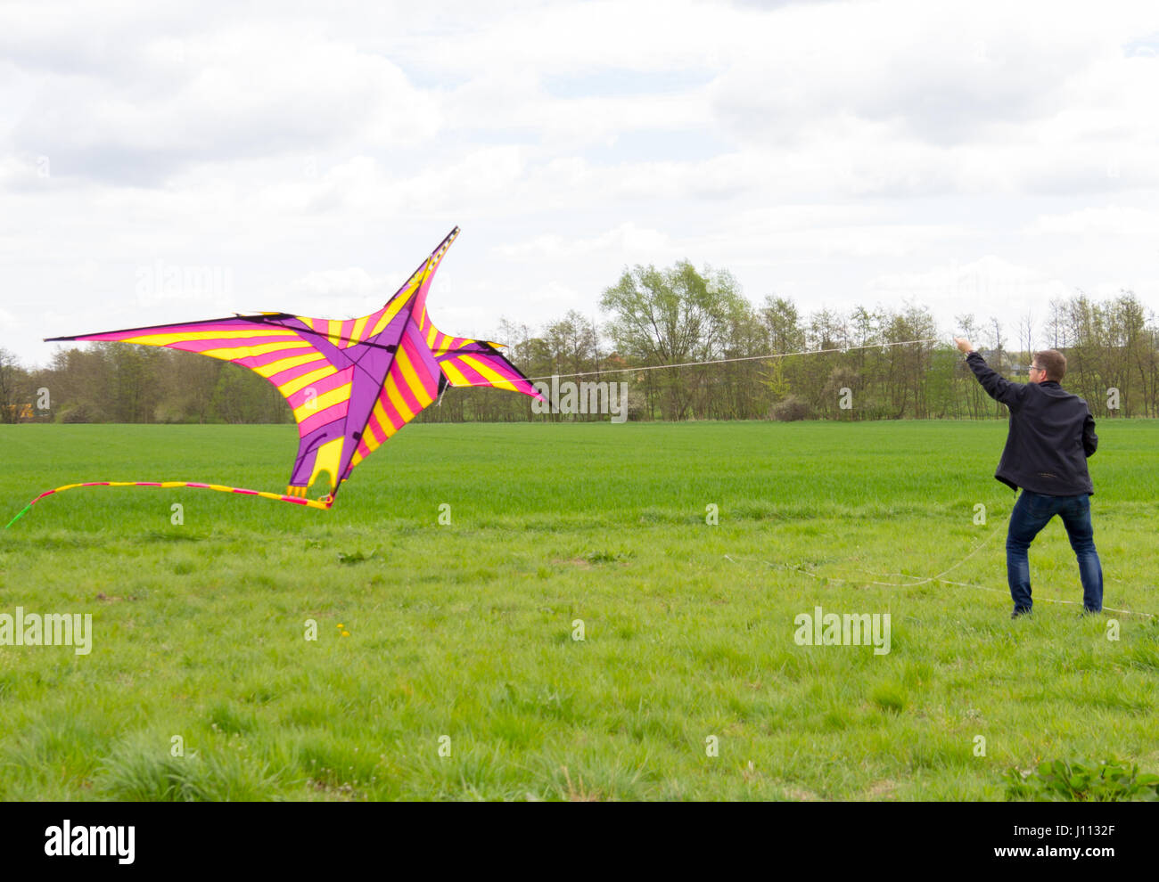 a man flies a coloured a kite Stock Photo Alamy