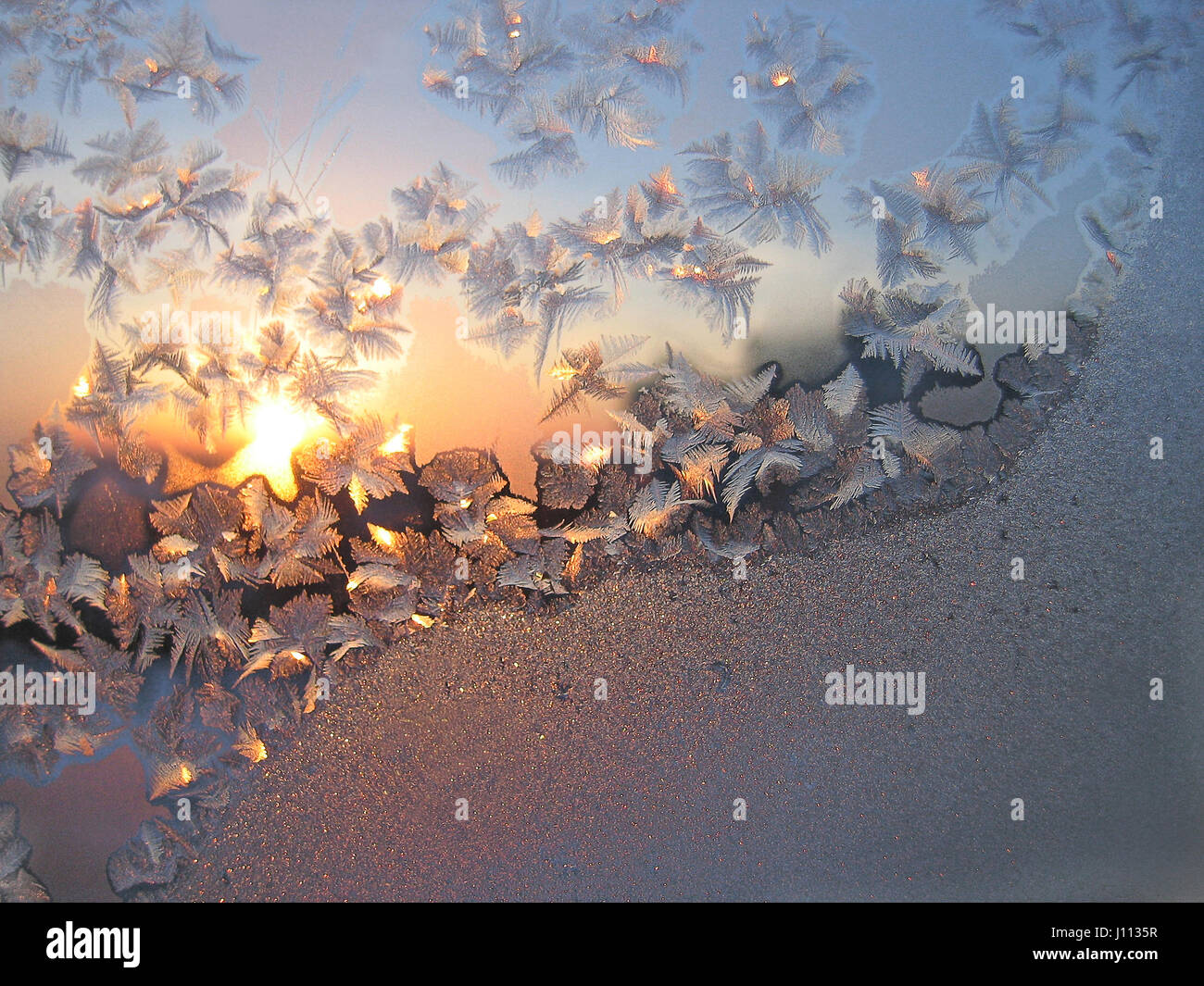 Frosty natural pattern and sun on winter glass Stock Photo - Alamy