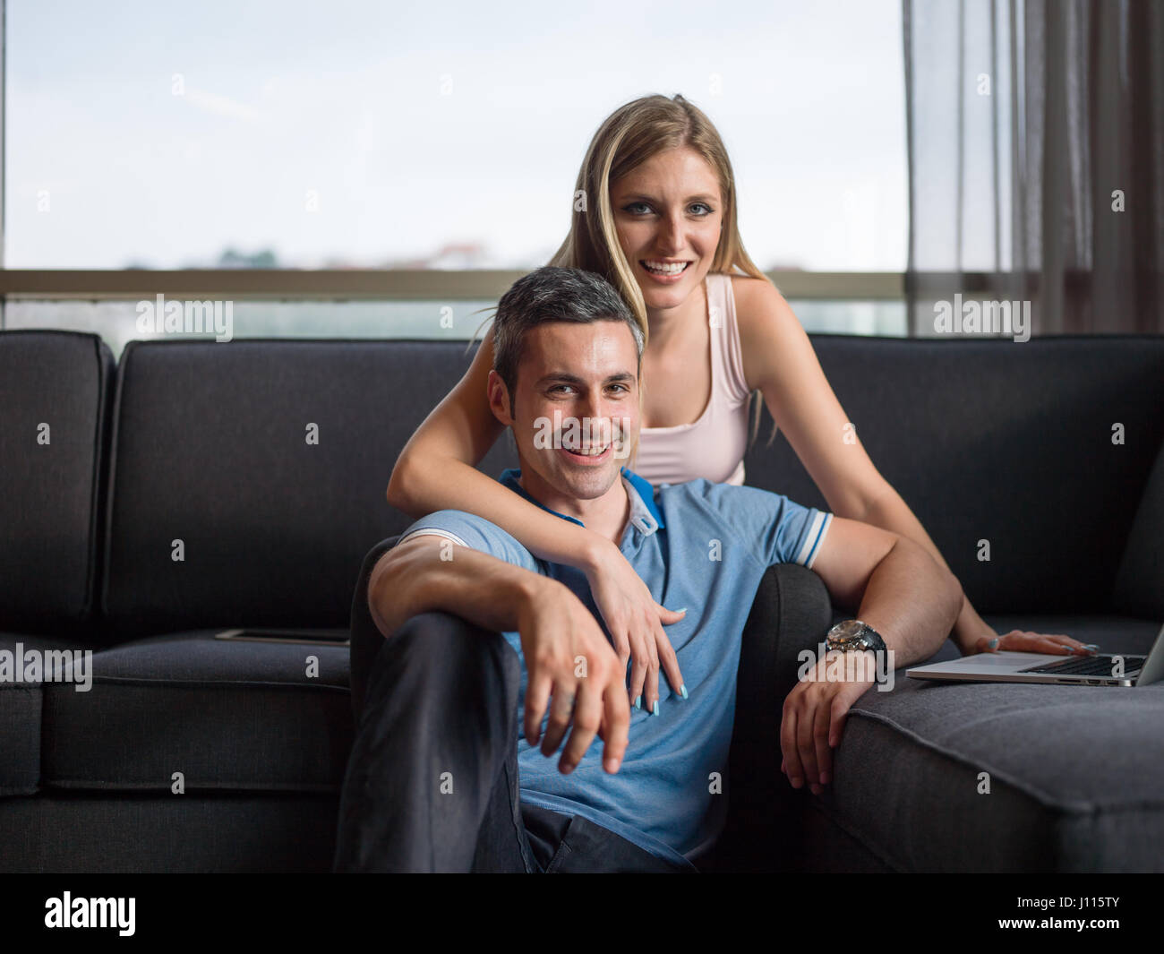 Attractive couple using a laptop in the living room Stock Photo - Alamy