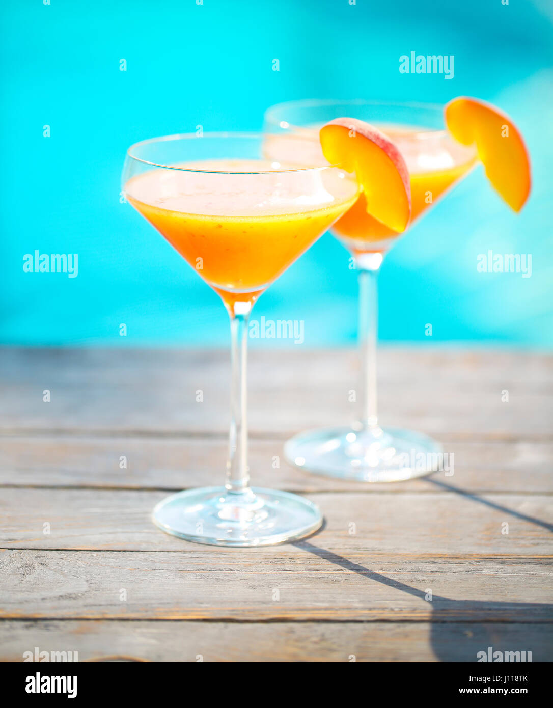 Champagne glasses with peach. Bellini cocktail. Summer pool party Stock