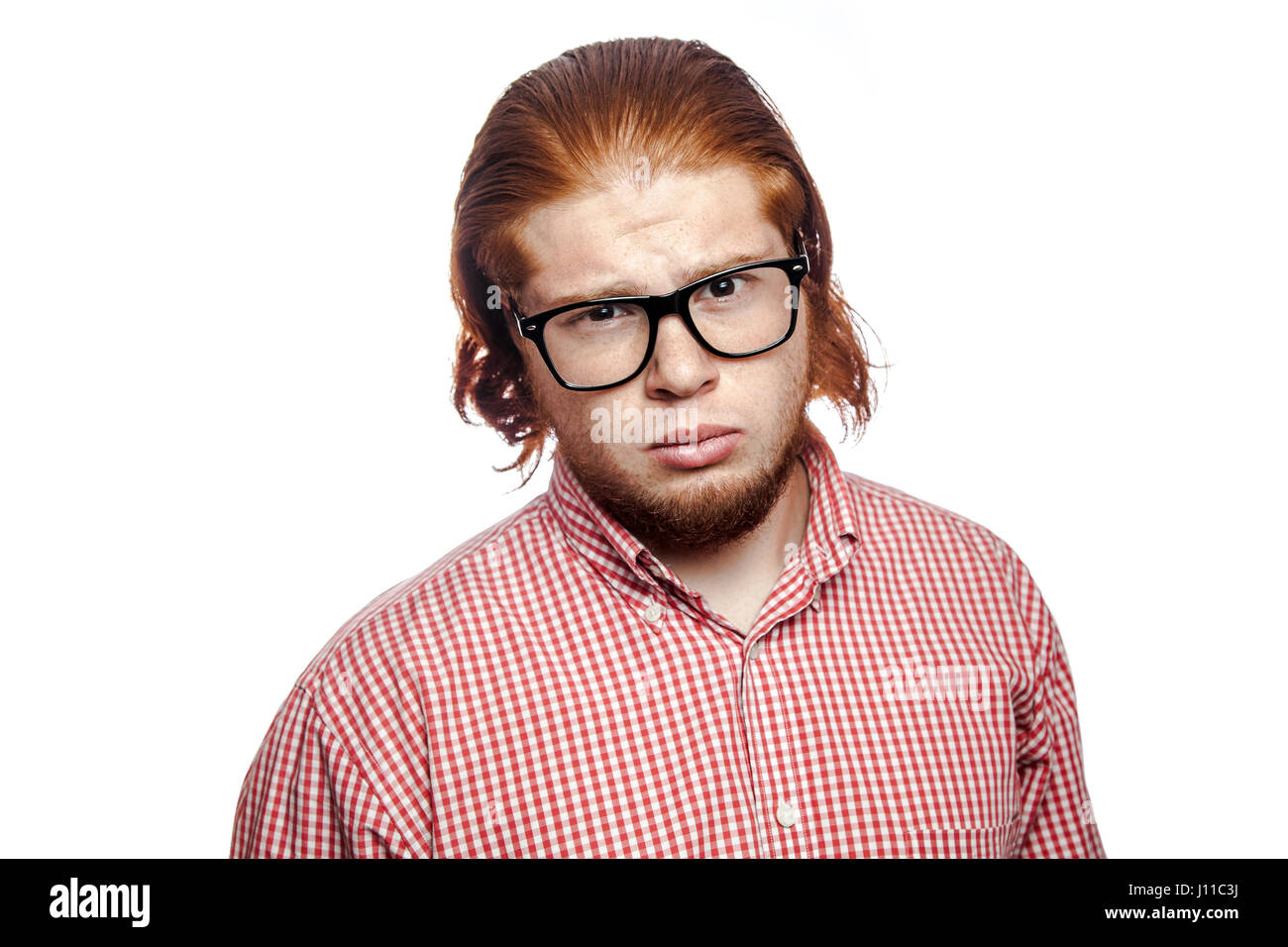 Sad unhappy bearded readhead businessman with red shirt and freckles and glasses looking at camera. studio shot isolated on white. Stock Photo