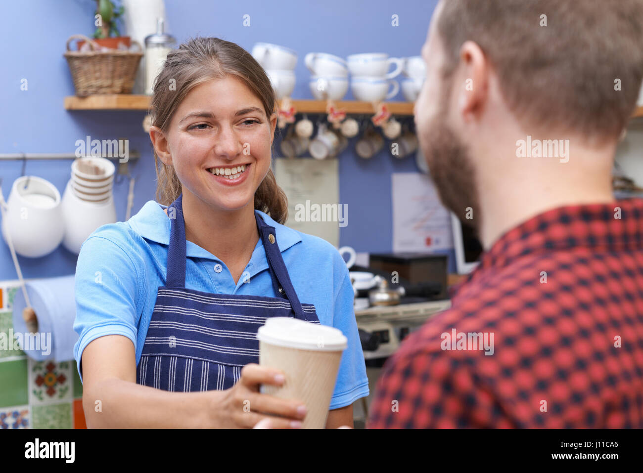 Female Cafe Worker Serving Customer With Takeaway Coffee Stock Photo Alamy
