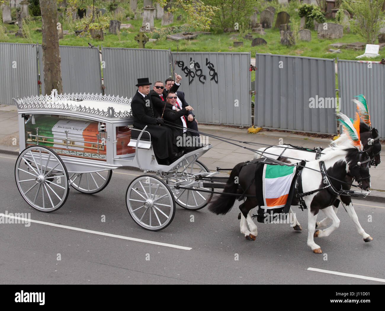 My Big Fat Gypsy Wedding star Paddy Doherty (centre), with his brothers Qe (front) and Johnny (right) on a horse drawn hearse carrying the coffin of their father Simon Doherty along Harrow Road, en route to St Margaret's Catholic Cemetery, London, to be buried after his funeral. Stock Photo