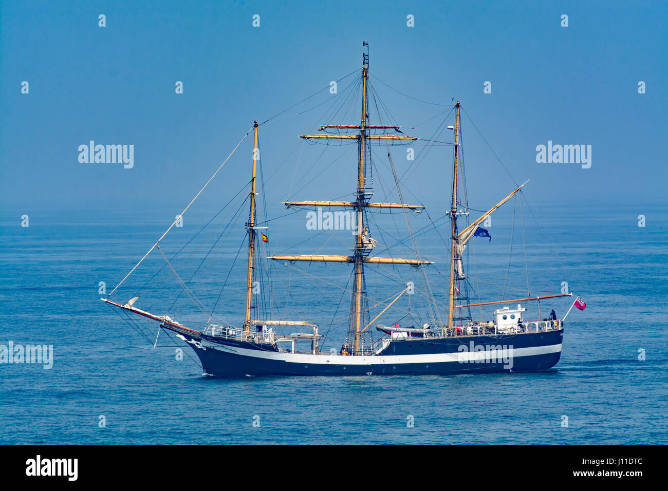 Tall Ship Sailing on Open Ocean Against Blue Sky Stock Photo Alamy